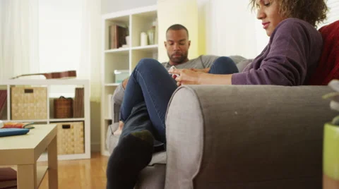 African American couple using devices on couch Video stock 41482226