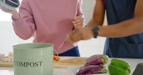 African American couple using tablet, chopping veg, dropping peels into compost Video stock 342843869