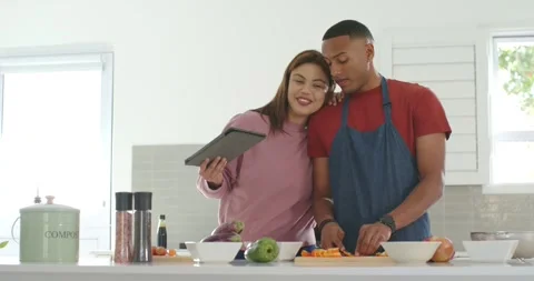 African American couple using tablet recipe, woman pointing, man in apron Stock Footage 344964477