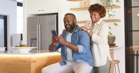 African American couple watching phone, man tapping, woman leaning over and Vídeo Stock 336685553