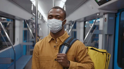 African-American courier with a backpack. A man with protective mask on his face Stock Footage 279727497