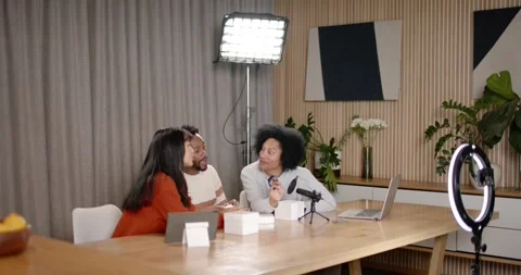 African American creators picking gadget from white box, passing to mic for demo Stock Footage 345607667