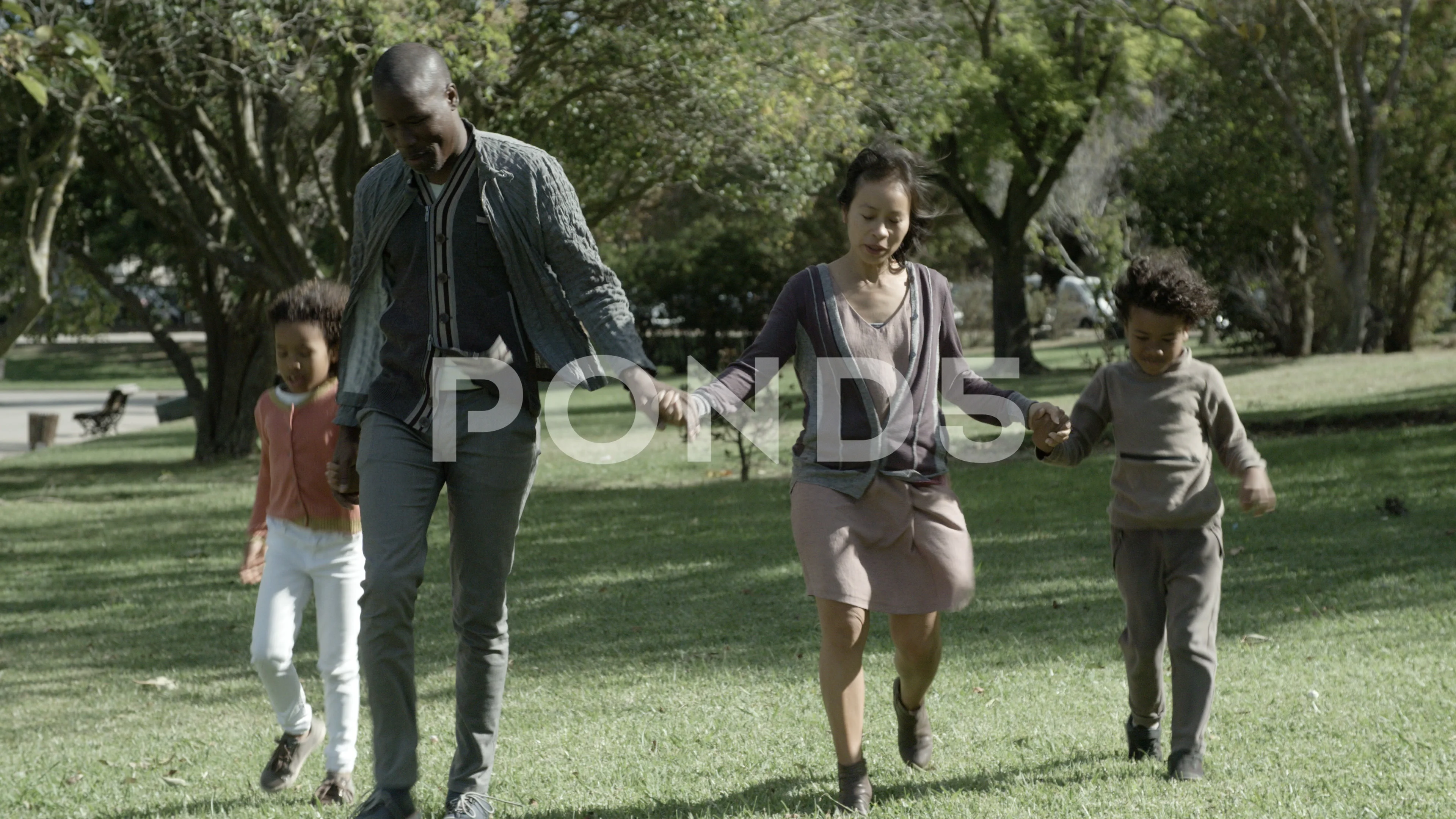 African American dad, Asian pretty mom and kids holding hands