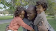 African American Dad Embracing Curly Children In Summer Park Stock Footage