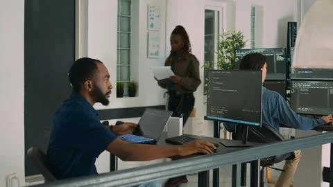 African american developer using laptop to write code and display system 库存照片