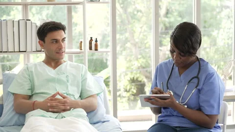African American doctor using digital tablet examining and talking to patie.. Stock Footage 278359377