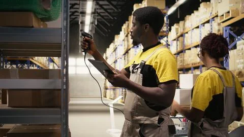 African american e-commerce worker scanning shipping labels numbers Fotos Stock