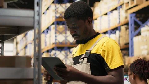 African american e-commerce worker scanning shipping labels numbers Fotos Stock