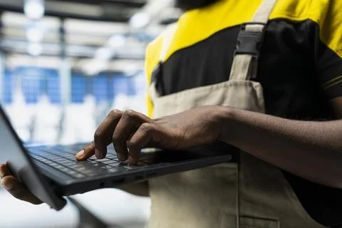 African american engineer adjusts parameters for solar power production Stock Photos