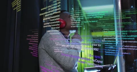 African American engineer processes data on laptop in server room, showcasing Stock Footage 330594005