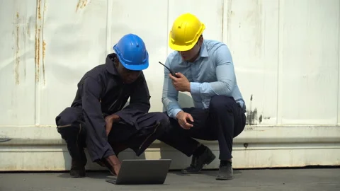 African american engineer sitting and holding laptop computer talking with bu Stock Footage 154690900