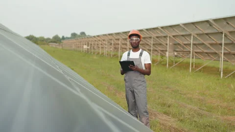 African american engineer writing notes on clipboard during inspection of solar Stock Footage 168592788