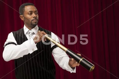 African American explorer in retro suit holding a telescope Stock Photos