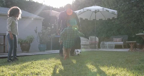 African American family playing football in yard Stock Footage