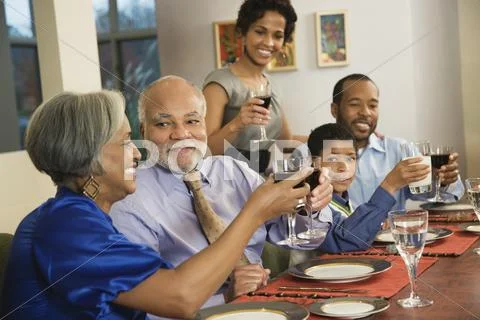 African American Family Toasting With Wine At Dining Table