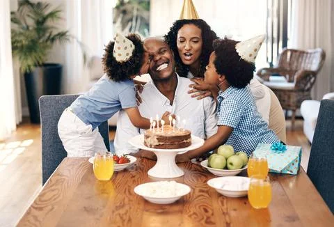 African american family wearing party hats and celebrating a birthday at home Stock Photos