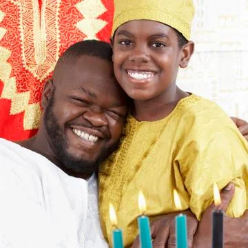 African american father hugging son in traditional clothing Stock Photos