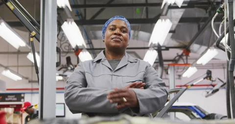 African American female car mechanic crossing her arms and looking at camera Stock Footage