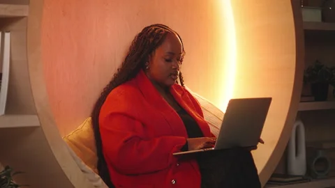 African American female programmer writes computer code on laptop in library Video stock 343435941