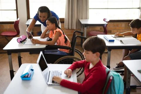 African american female teacher teaching disabled girl to use digital tablet at Stock Photos