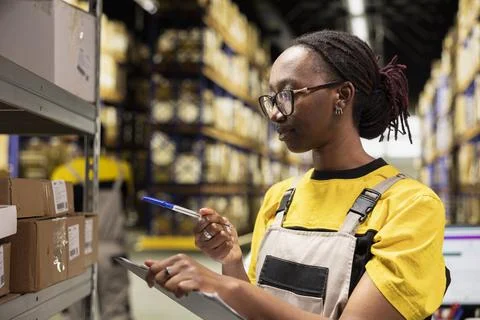 African american female worker checking tracking numbers tags 스톡 사진