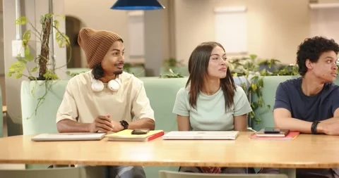 African American friends at study table noticing left motion, turning heads and Stock Footage 344331109
