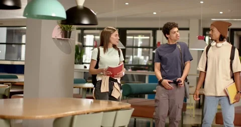 African American friends walking in study lounge after eye contact, holding red Stock Footage 344948753