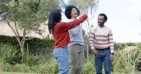 African American friends in yard clapping, woman in red sweater starting arm Stock-Footage 345607809