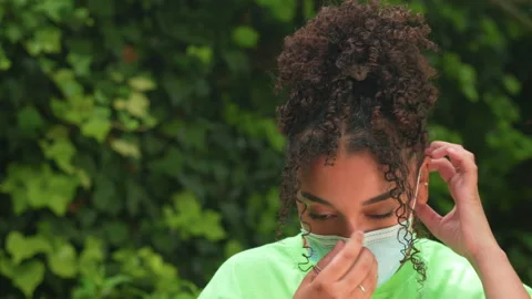 African American girl biracial teenager young woman putting on face mask Stock Footage
