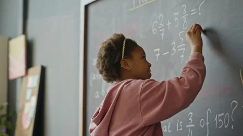 African American Girl Solving Math Problem on Blackboard with Teacher Stock Footage 340549007