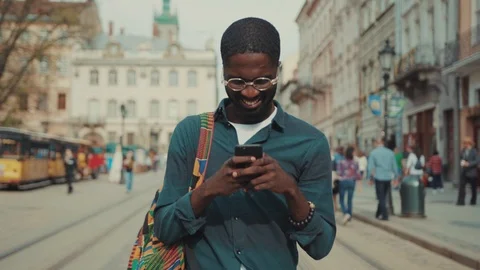African American with glasses man using phone walking in city technology Stock Footage 91337898