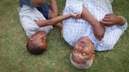 African American Grandad And Grandson Play Lying On Grass, Aerial View Stock Footage
