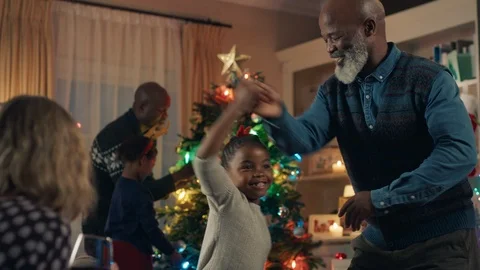 African american grandfather dancing with little girl on christmas eve happy Stock Footage
