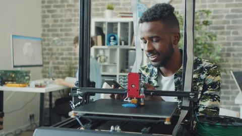African American guy using 3d printer in office enjoying modern technology Stock Footage 119557334
