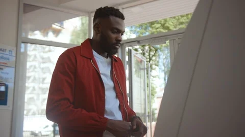 African american guy using an ATM machine entering a pin code on keyboard Stock Footage 110459977