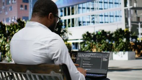 African american guy works on programming code on terminal window 库存照片