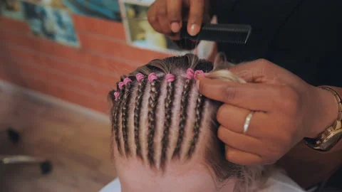 African American Hairdresser coiffeur weaves French braids, bride's hairstyle. Stock Footage