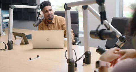 African American hosts at studio table, host talking into mic, right host Stock-Footage 342642166