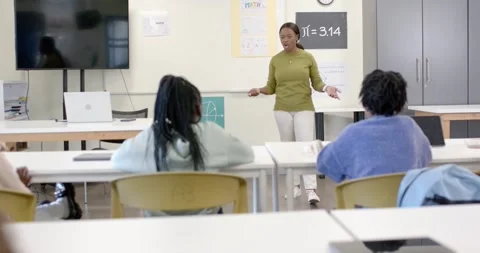 African American instructor gesturing while teaching math at board after Stock Footage 341028313