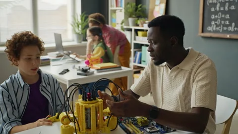 African American Instructor Teaching Boy Robotics in Stem Classroom Stock Footage 340554169