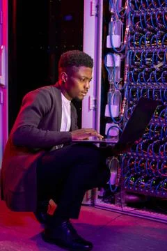 African American IT engineer analyzing work of server Stock Photos
