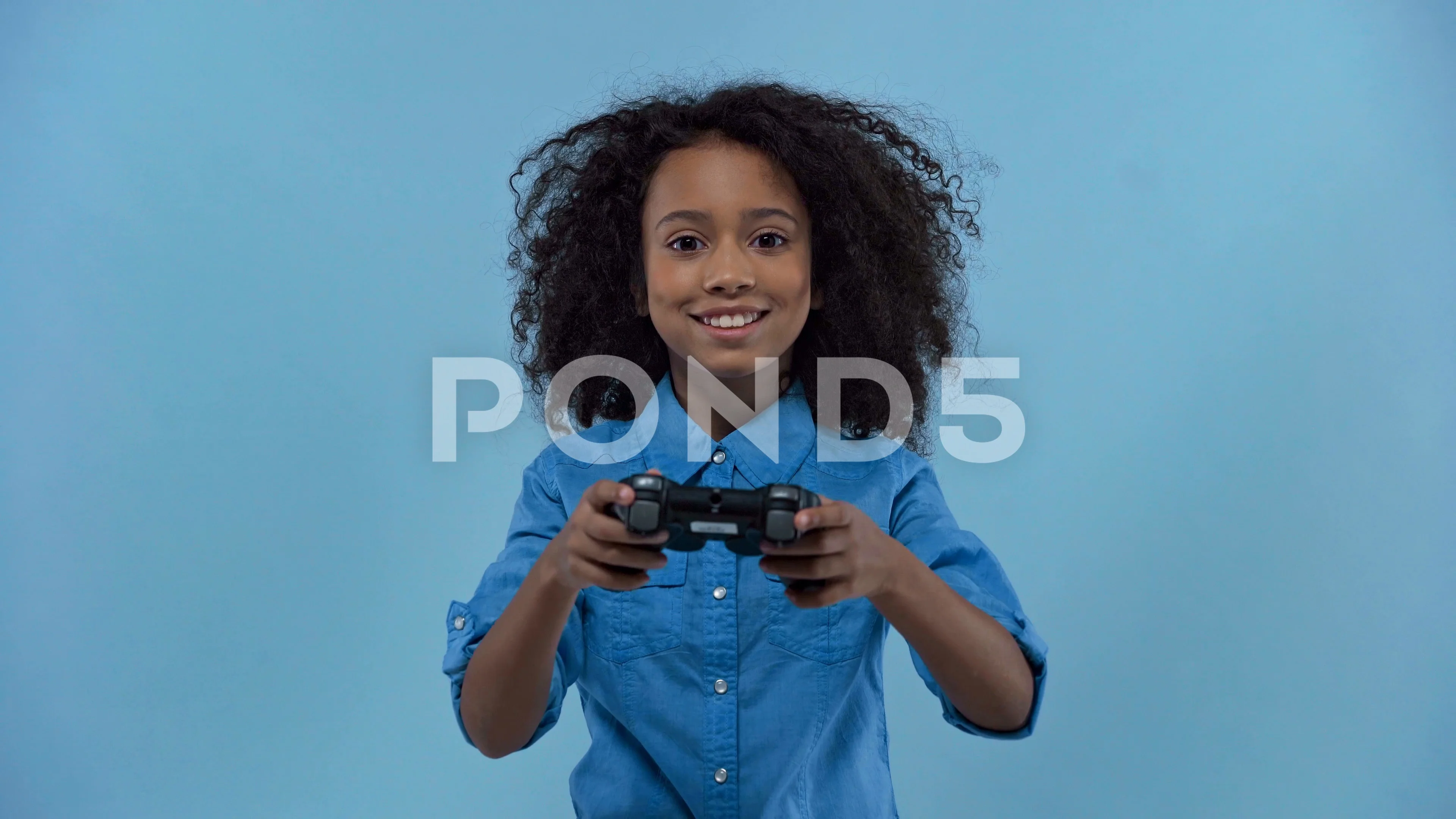 african american kid playing video game isolated on blue