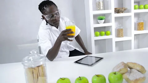 African American lab technician studying nutrition of food with a tablet compute Vídeos de archivo 199629241