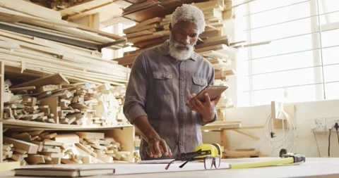 African american male carpenter using digital tablet in a carpentry shop Stock Footage 335364321