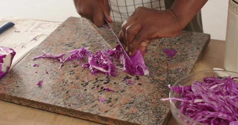African American male placing cabbage wedge, shredding with chef's knife on Vidéo 345072353