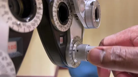 African American Man adjusting dials on phoropter used for eye examination or te Stock Footage 180488532