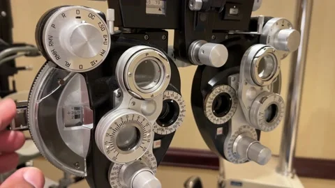 African American Man adjusting dials on phoropter used for eye examination or te Stock Footage 180488588
