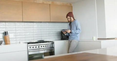 African American man checking knobs in kitchen, tapping tablet turning cabinet Stock Footage 335927617