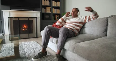 African American man checking phone, picking up headphones, putting on and Stock Footage 342363537