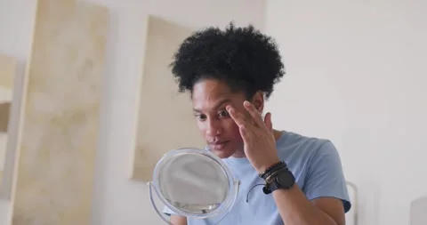 African American man checking right eye at bedroom mirror, pressing under eye Stock Footage 337261670